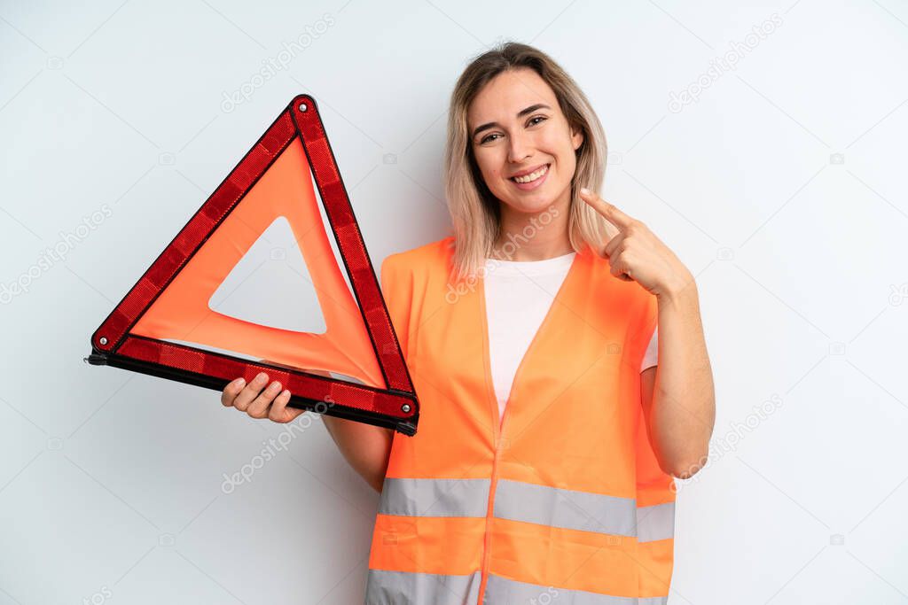 blonde pretty woman smiling confidently pointing to own broad smile. car emergency concept
