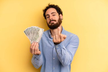 Genç adam kızgın, sinirli, asi ve agresif hissediyor. Dolar banknotları konsepti