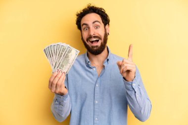 Genç adam bir fikri fark ettikten sonra mutlu ve heyecanlı bir dahi gibi hissediyor. Dolar banknotları konsepti