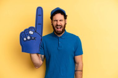 Genç adam agresif bir şekilde bağırıyor, çok kızgın görünüyor. Bir el fan konsepti