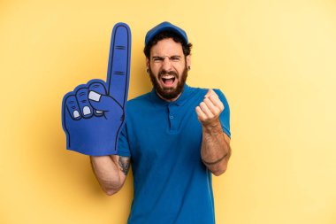 Genç adam öfkeli bir ifadeyle agresif bir şekilde bağırıyor. Bir el fan konsepti