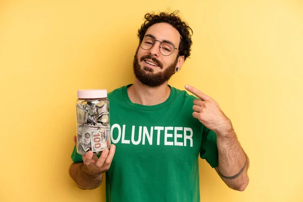 young man smiling confidently pointing to own broad smile. volunteer concept