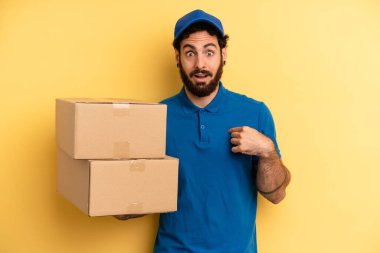 Genç adam mutlu hissediyor ve heyecanla kendini işaret ediyor. Şirket çalışanı konsepti