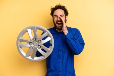 Genç adam kendini mutlu hissediyor, elleri ağzının kenarında bağırarak bağırıyor. araba mekaniği kavramı