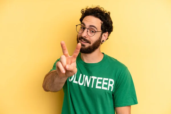 Joven Sonriendo Mirando Feliz Haciendo Gestos Victoria Paz Concepto Voluntario —  Fotos de Stock