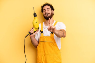 Genç adam gururla gülümsüyor ve kendinden emin bir numara oluyor. Matkap ustası.