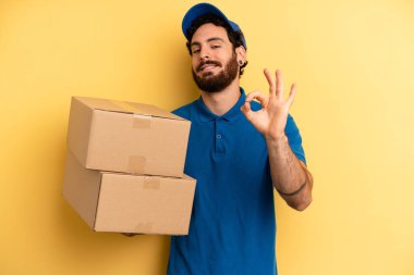 Genç adam kendini mutlu hissediyor, iyi bir jestle onaylıyor. Şirket çalışanı konsepti