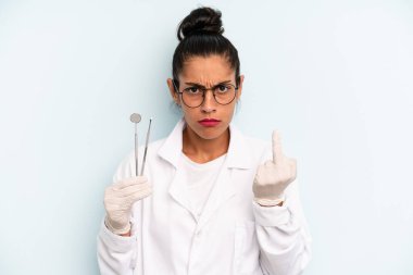 hispanic woman feeling angry, annoyed, rebellious and aggressive. dentist concept
