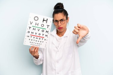 hispanic woman feeling cross,showing thumbs down. optical vision test concept