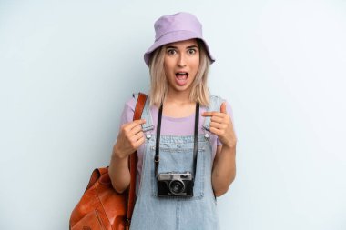 blonde woman feeling happy and pointing to self with an excited. summer tourist concept
