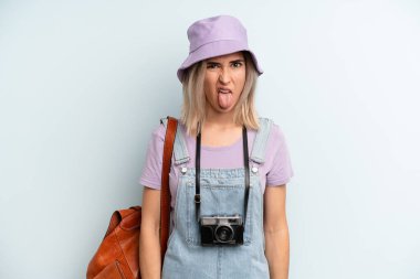 Sarışın kadın iğreniyor, sinirleniyor ve dilini çıkarıyor. Yaz turizmi kavramı