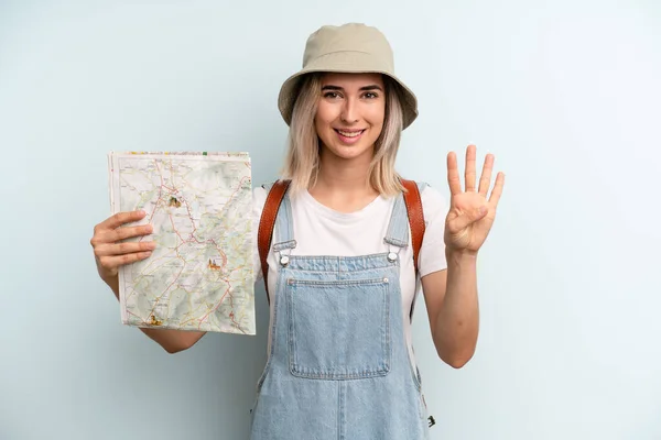 Blonde Woman Smiling Looking Friendly Showing Number Four Tourist Map — Zdjęcie stockowe