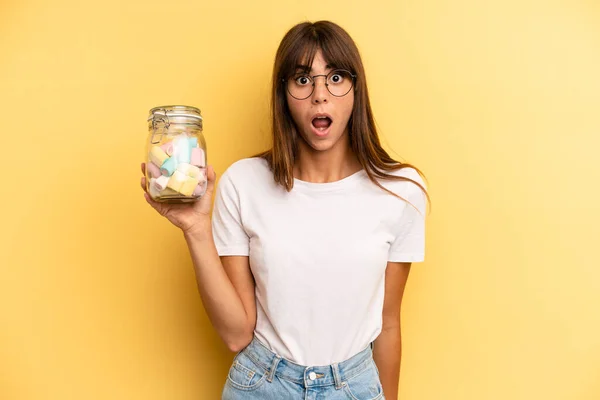 Hispanic Woman Looking Very Shocked Surprised Candies Bottle Concept — Φωτογραφία Αρχείου