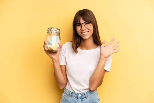 Hispanic Woman Smiling Happily Waving Hand Welcoming Greeting You Candies — Foto de Stock