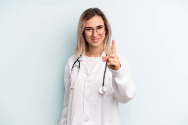 Sarışın kadın gururla gülümsüyor ve kendinden emin bir numara oluyor. tıp öğrencisi konsepti