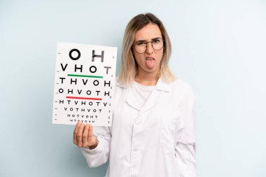 Sarışın kadın iğreniyor, sinirleniyor ve dilini çıkarıyor. optik görüş testi konsepti