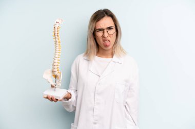 Sarışın kadın iğreniyor, sinirleniyor ve dilini çıkarıyor. tıp öğrencisi konsepti