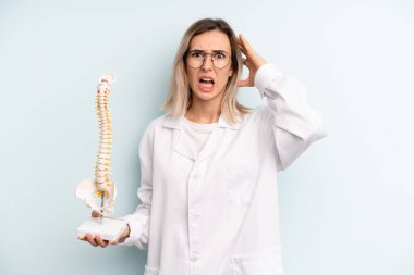 Sarışın kadın kendini stresli, endişeli ya da korkmuş hissediyor, elleri başının üstünde. tıp öğrencisi konsepti