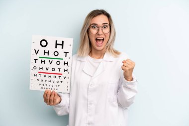 Sarışın kadın şokta, gülüyor ve başarıyı kutluyor. optik görüş testi konsepti