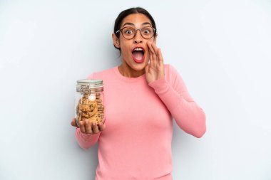 İspanyol kadın kendini mutlu hissediyor, elleri ağzının kenarında bağırıyor. Ev yapımı kurabiye konsepti