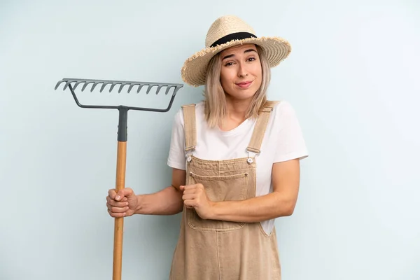 Blonde Woman Shrugging Feeling Confused Uncertain Farmer Rake Cocnept — Stockfoto