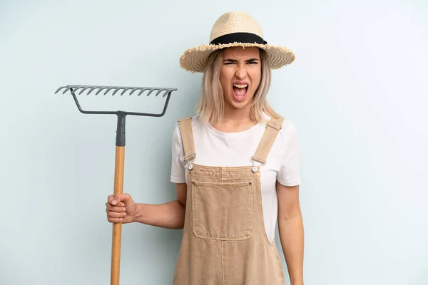 Blonde Woman Shouting Aggressively Looking Very Angry Farmer Rake Cocnept — Foto Stock