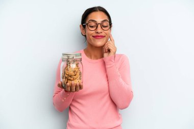 İspanyol kadın mutlu, kendinden emin, elleri çenesinde gülümsüyor. Ev yapımı kurabiye konsepti