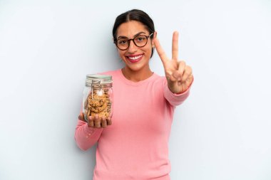 İspanyol kadın gülümsüyor ve mutlu görünüyor, zafer ya da barış işareti yapıyor. Ev yapımı kurabiye konsepti