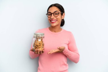 İspanyol kadın neşeyle gülümsüyor, mutlu hissediyor ve bir konsept gösteriyor. Ev yapımı kurabiye konsepti