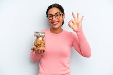 İspanyol kadın kendini mutlu hissediyor, iyi bir jestle onaylıyor. Ev yapımı kurabiye konsepti