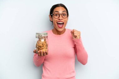 İspanyol kadın şokta, gülüyor ve başarıyı kutluyor. Ev yapımı kurabiye konsepti