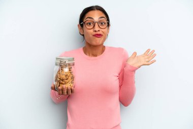 İspanyol kadın şaşkın, şaşkın ve şüpheci hissediyor. Ev yapımı kurabiye konsepti