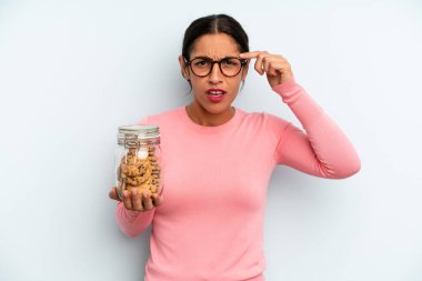 İspanyol kadın şaşkın ve şaşkın hissediyor, senin deli olduğunu gösteriyor. Ev yapımı kurabiye konsepti