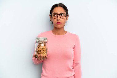 Hispanik kadın üzgün, üzgün ya da kızgın ve yana bakıyor. Ev yapımı kurabiye konsepti