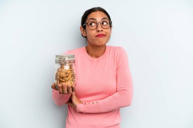 İspanyol kadın omuz silkiyor, kafası karışık ve kararsız. Ev yapımı kurabiye konsepti