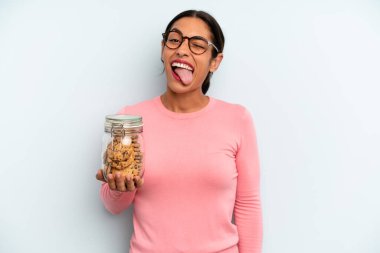 Neşeli ve asi tavırlı İspanyol kadın, şaka yapıyor ve dil çıkarıyor. Ev yapımı kurabiye konsepti