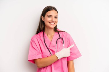 Güzel bir kadın neşeyle gülümsüyor, mutlu hissediyor ve bir tarafı işaret ediyor. hemşire konsepti