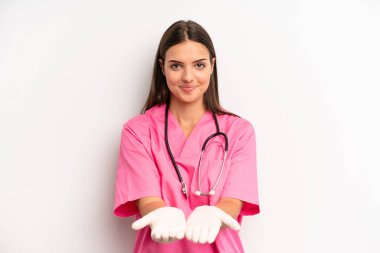 Güzel bir kadın mutlu bir şekilde gülümsüyor ve bir konsept sunuyor. hemşire konsepti