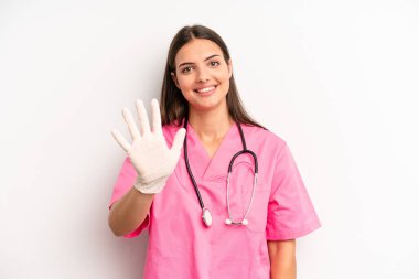 Güzel bayan gülümsüyor ve arkadaş canlısı görünüyor, beş numarayı gösteriyor. hemşire konsepti