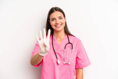 Güzel bayan gülümsüyor ve arkadaş canlısı görünüyor, dört numarayı gösteriyor. hemşire konsepti