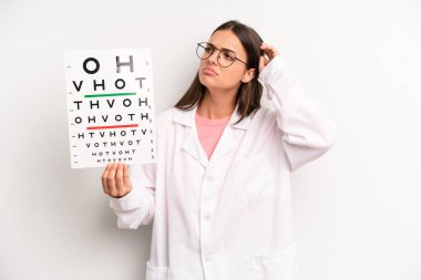 Güzel kadın şaşkın ve kafası karışık, kaşınan bir kafa hissediyor. optik görüş testi konsepti