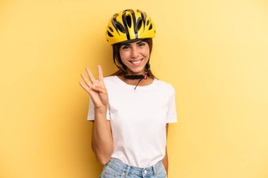 pretty woman smiling and looking friendly, showing number four. bike sport concept