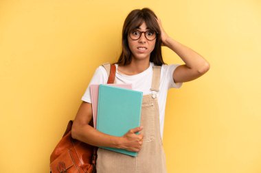 Güzel bir kadın stresli, endişeli ya da korkmuş hissediyor. Elleri başının üstünde. Üniversite öğrencisi konsepti