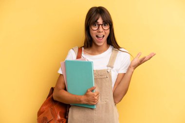 Güzel bir kadın kendini mutlu hissediyor ve inanılmaz bir şeye hayret ediyor. Üniversite öğrencisi konsepti