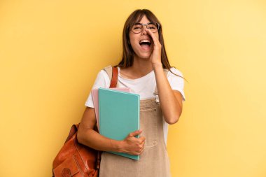 Güzel bir kadın kendini mutlu hissediyor, elleri ağzının kenarında bağırıyor. Üniversite öğrencisi konsepti