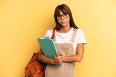 Güzel bir kadın omuz silkiyor, kafası karışık ve kararsız hissediyor. Üniversite öğrencisi konsepti