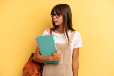 Profil görünümlü güzel bir kadın hayal kuruyor, hayal ediyor ya da hayal kuruyor. Üniversite öğrencisi konsepti