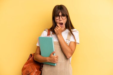 Ağzı ve gözleri açık, eli çenesinde güzel bir kadın. Üniversite öğrencisi konsepti