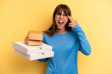 pretty woman looking unhappy and stressed, suicide gesture making gun sign. take away fast food concept
