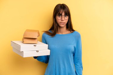 pretty woman looking puzzled and confused. take away fast food concept